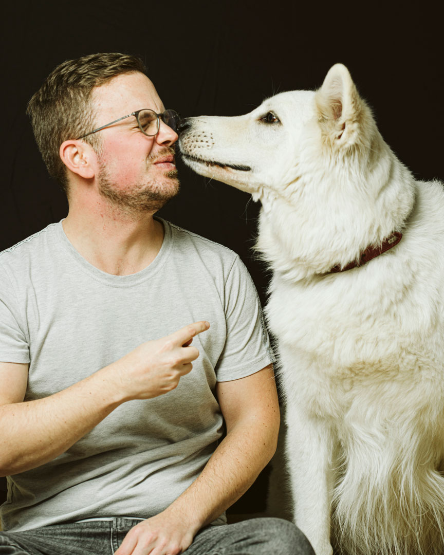 familienfotografie-biszummondundwiederzurueck-duesseldorf14 Gesicht eines jungen Mannes wurde soeben von seinem Hund abgeschleckt. Der Mann verzieht das Gesicht.