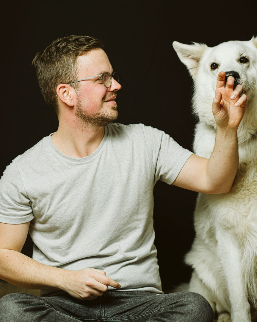familienfotografie-biszummondundwiederzurueck-duesseldorf15 Junger Mann laesst seinen Hund an seiner Hand riechen.