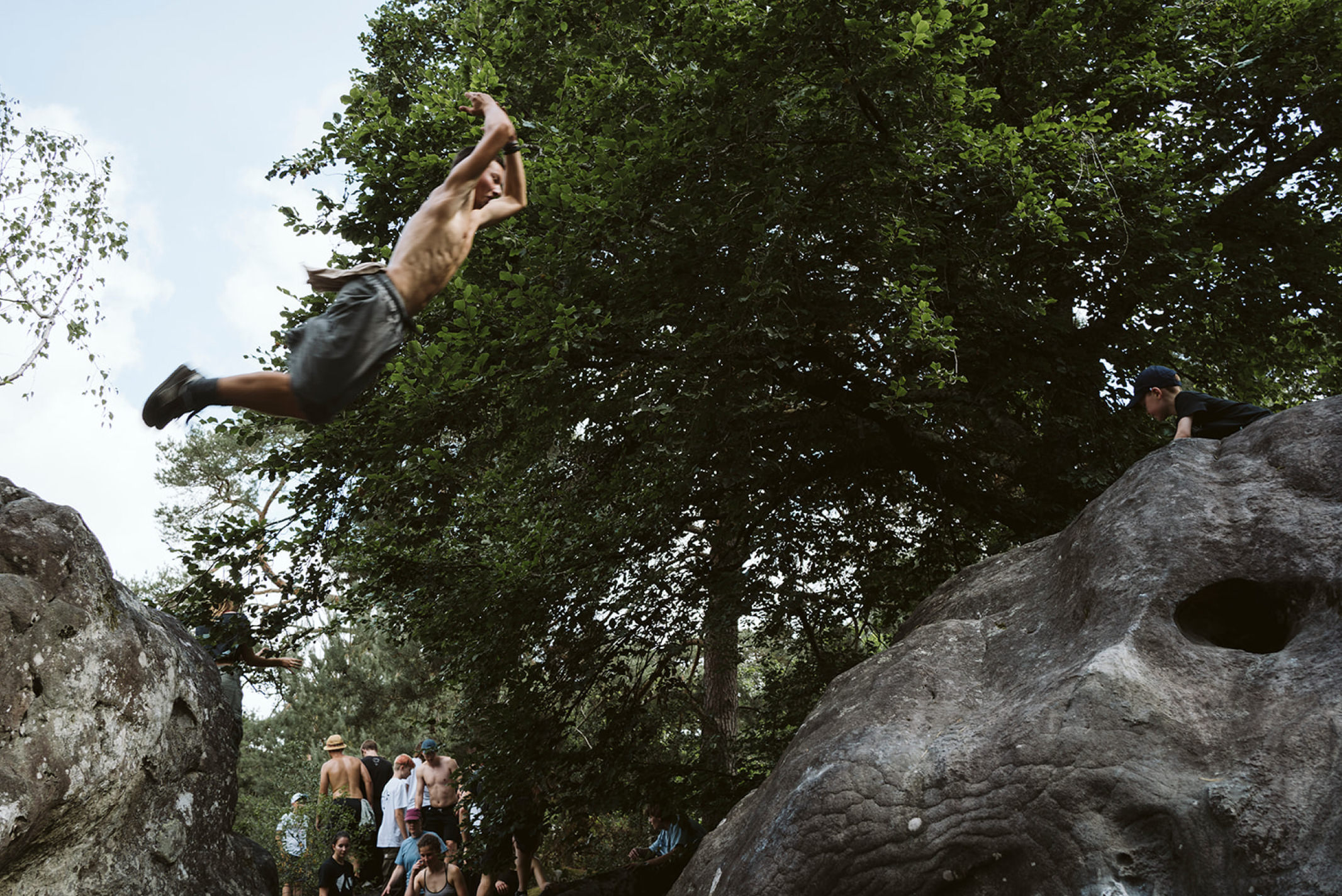 Parkour Fontainebleau 2025 – Jugendlicher mitten in der Luft im Sprung zwischen zwei Felsen