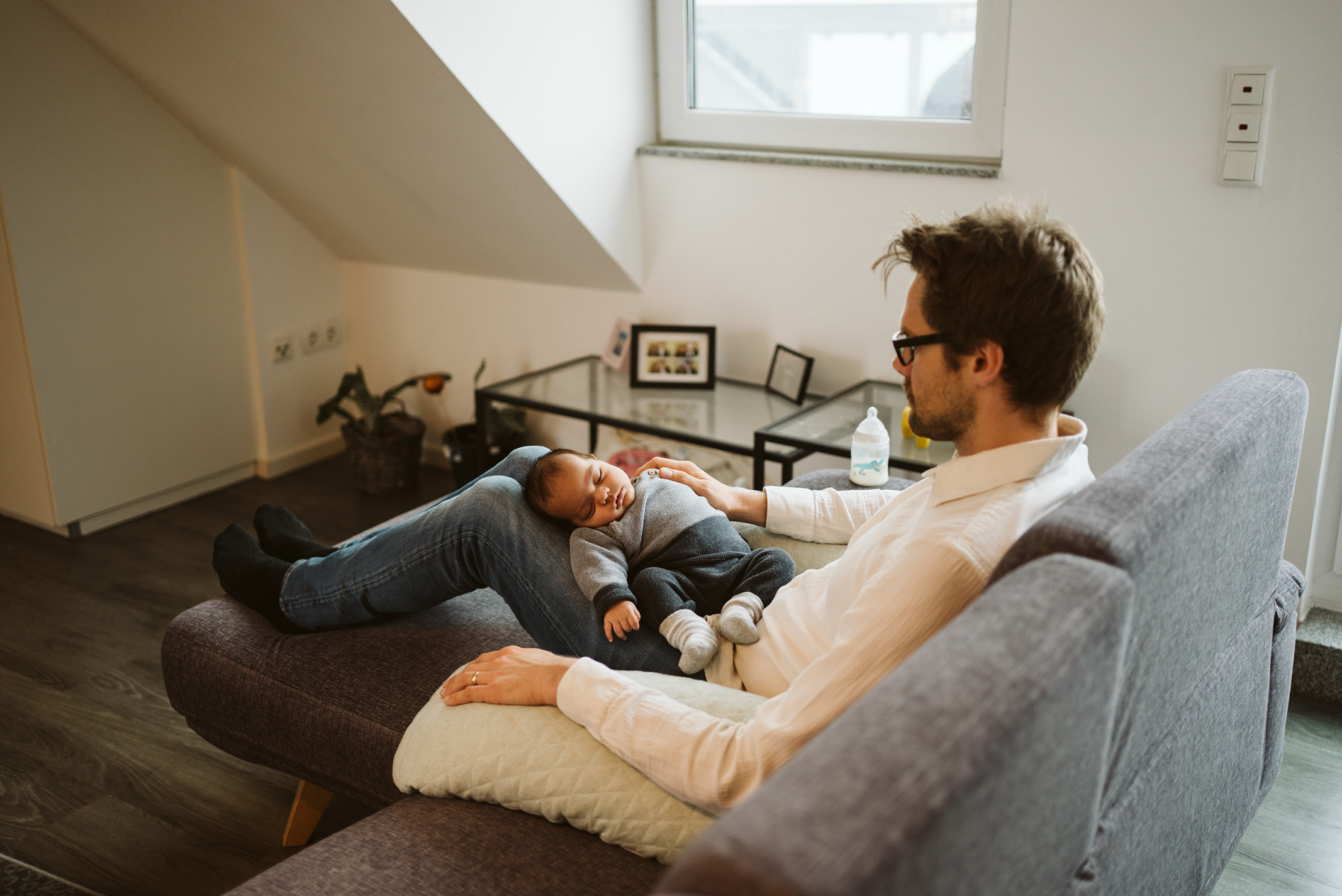 Vater kuschelt mit seinem Baby auf dem Sofa
