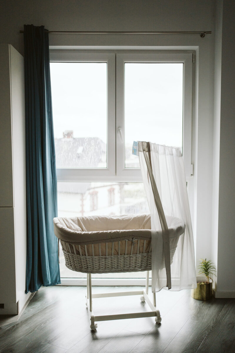 Babybett am Fenster im Zuhause einer jungen Familie