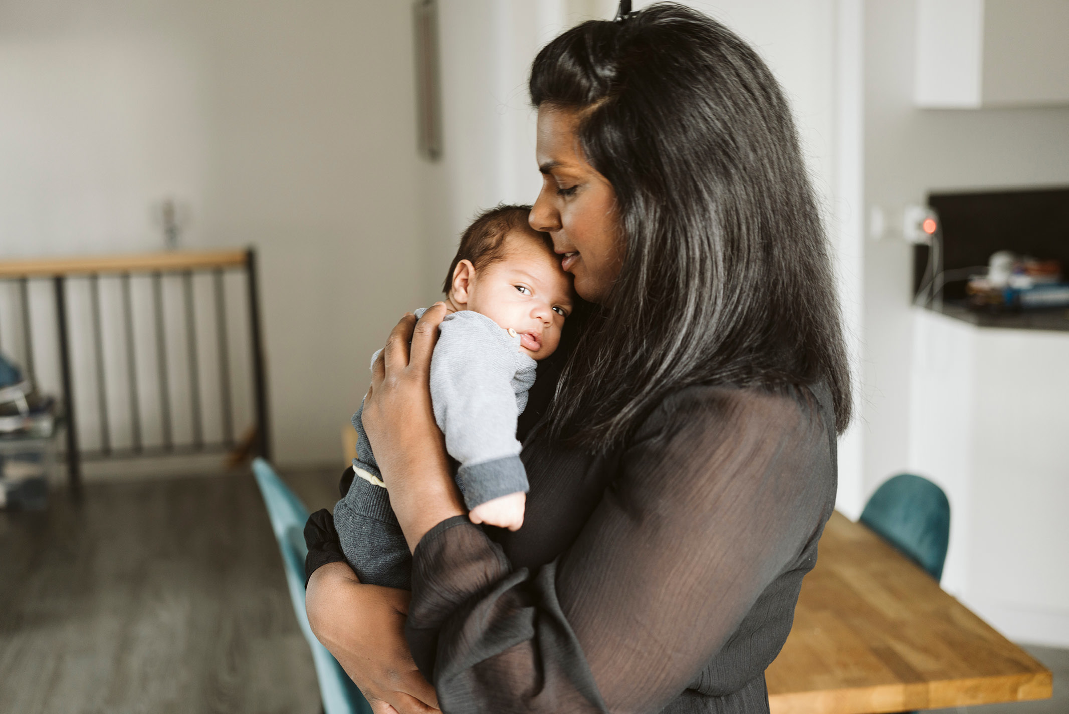 Mutter wiegt ihr Baby zu Hause liebevoll im Arm