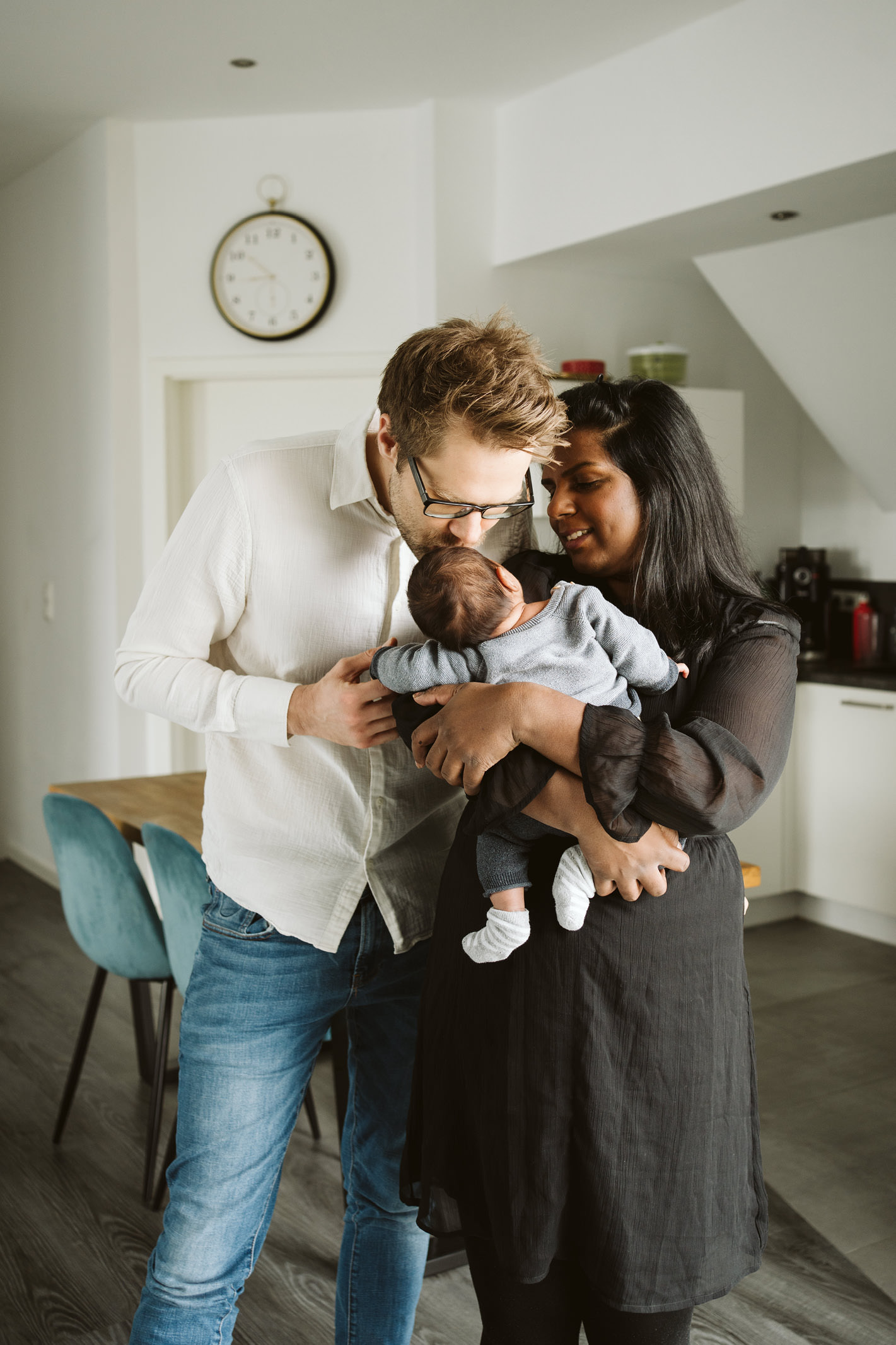 Eltern stehen gemeinsam mit ihrem Baby in ihrer Wohnung